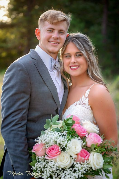 groom and bride holding white and pink bouquet