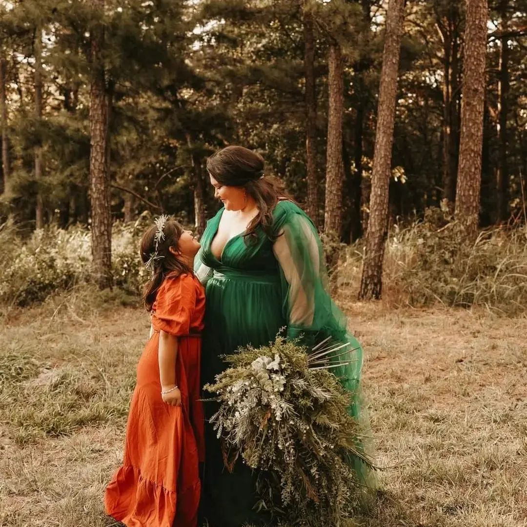 bride in green gown hugging her daughter