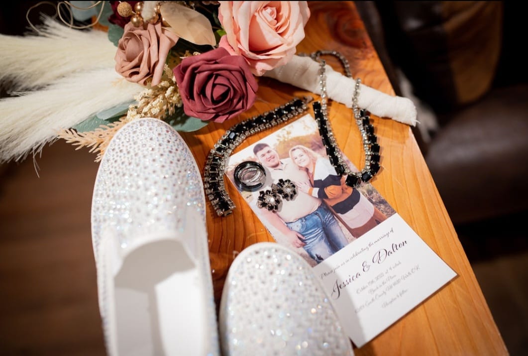 detail shot of wedding invitation, bride's shoes, bouquet, and jewelry