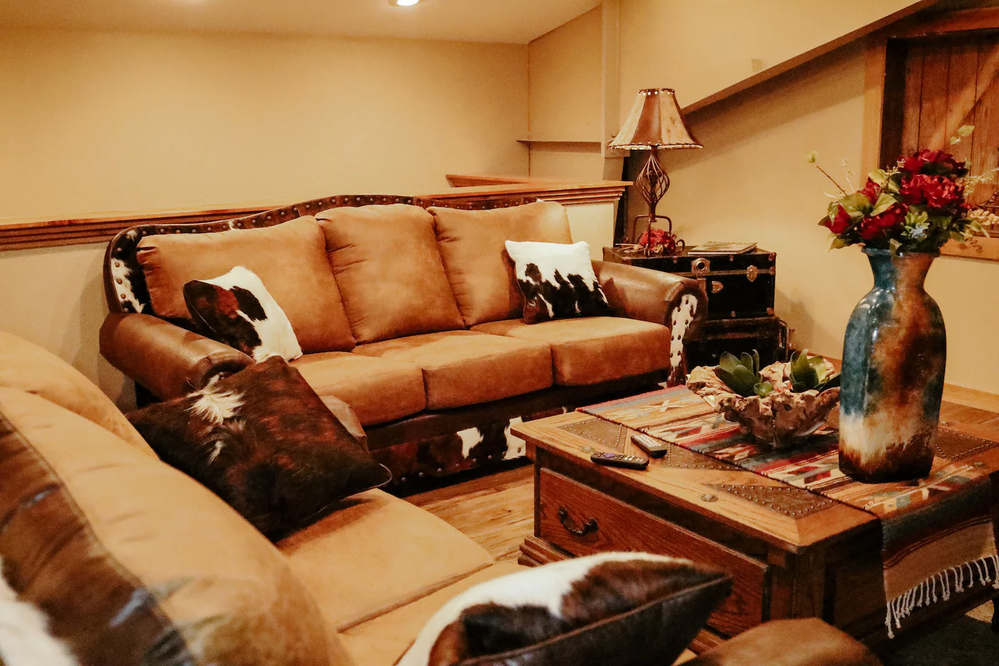 living room with leather and cowhide couches and western decor