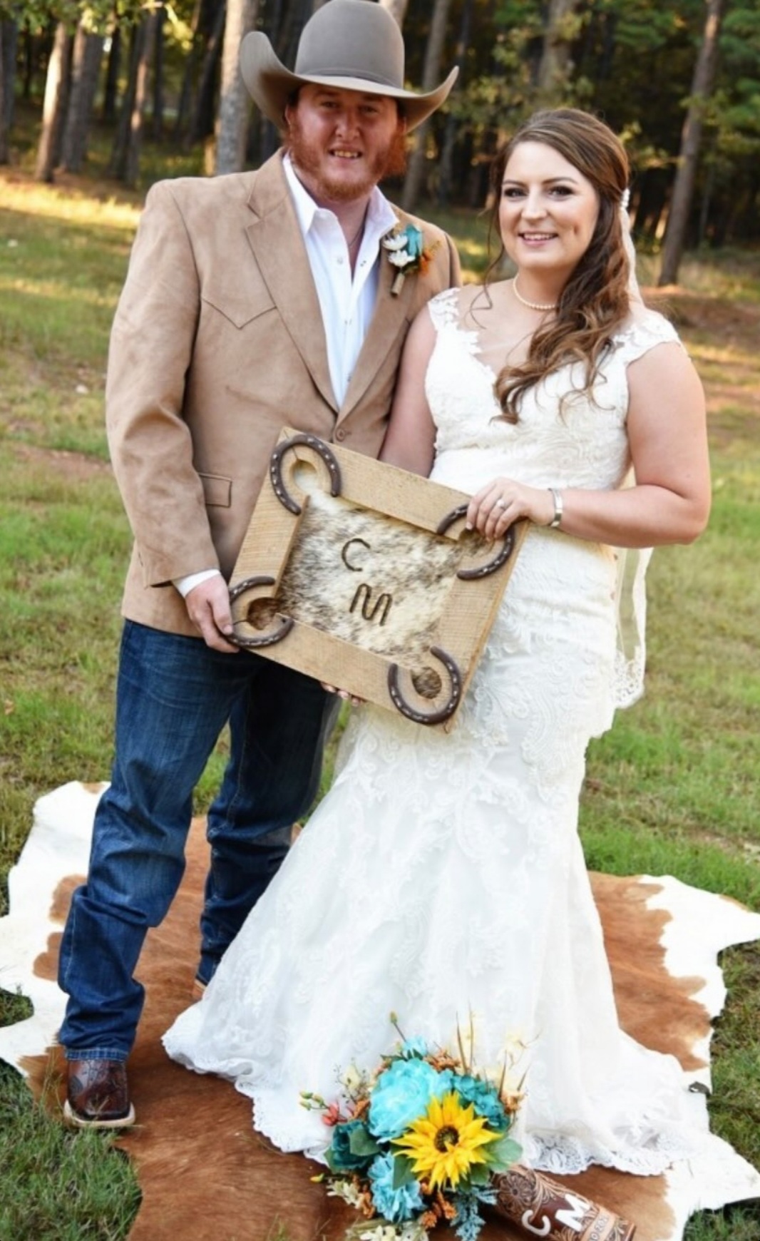 bride and groom holding custom branded keepsake standing on cowhide rug