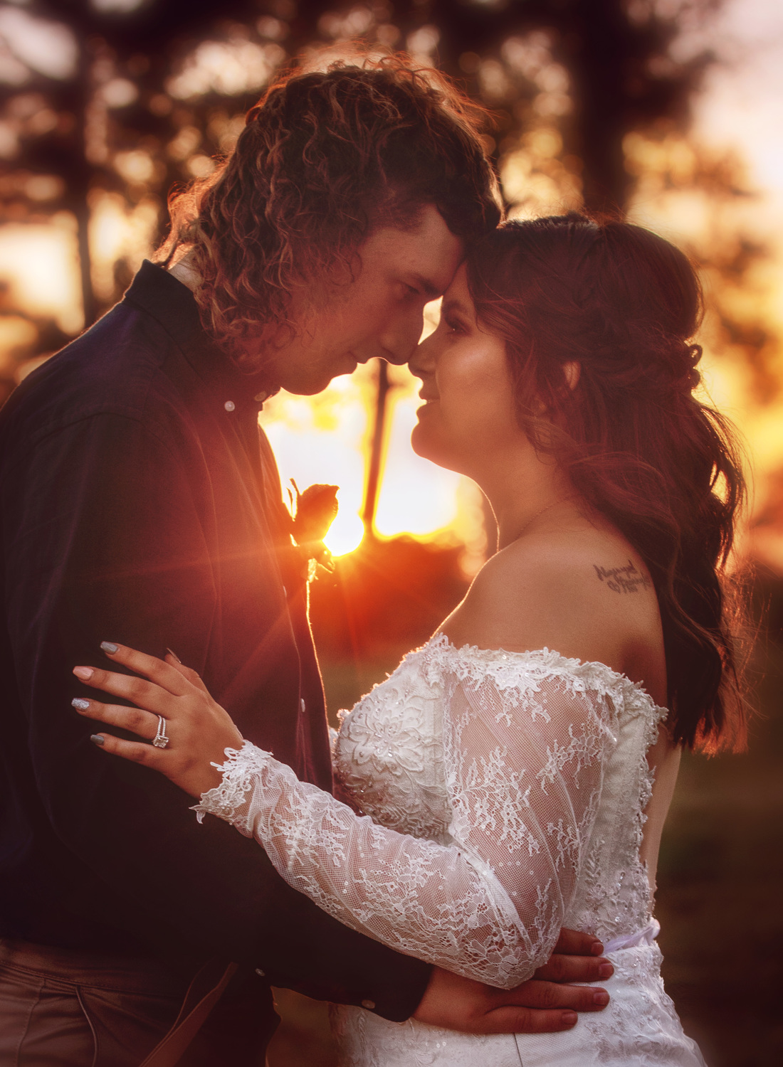 groom and bride embracing at sunset